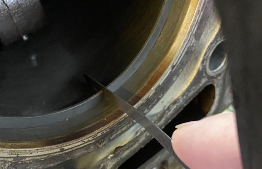 Mit der Fühlerlehre messen. Meistens ist es so eng, dass nur 0,05 passt. Wieder herausnehmen und langsam herantasten bis es passt.